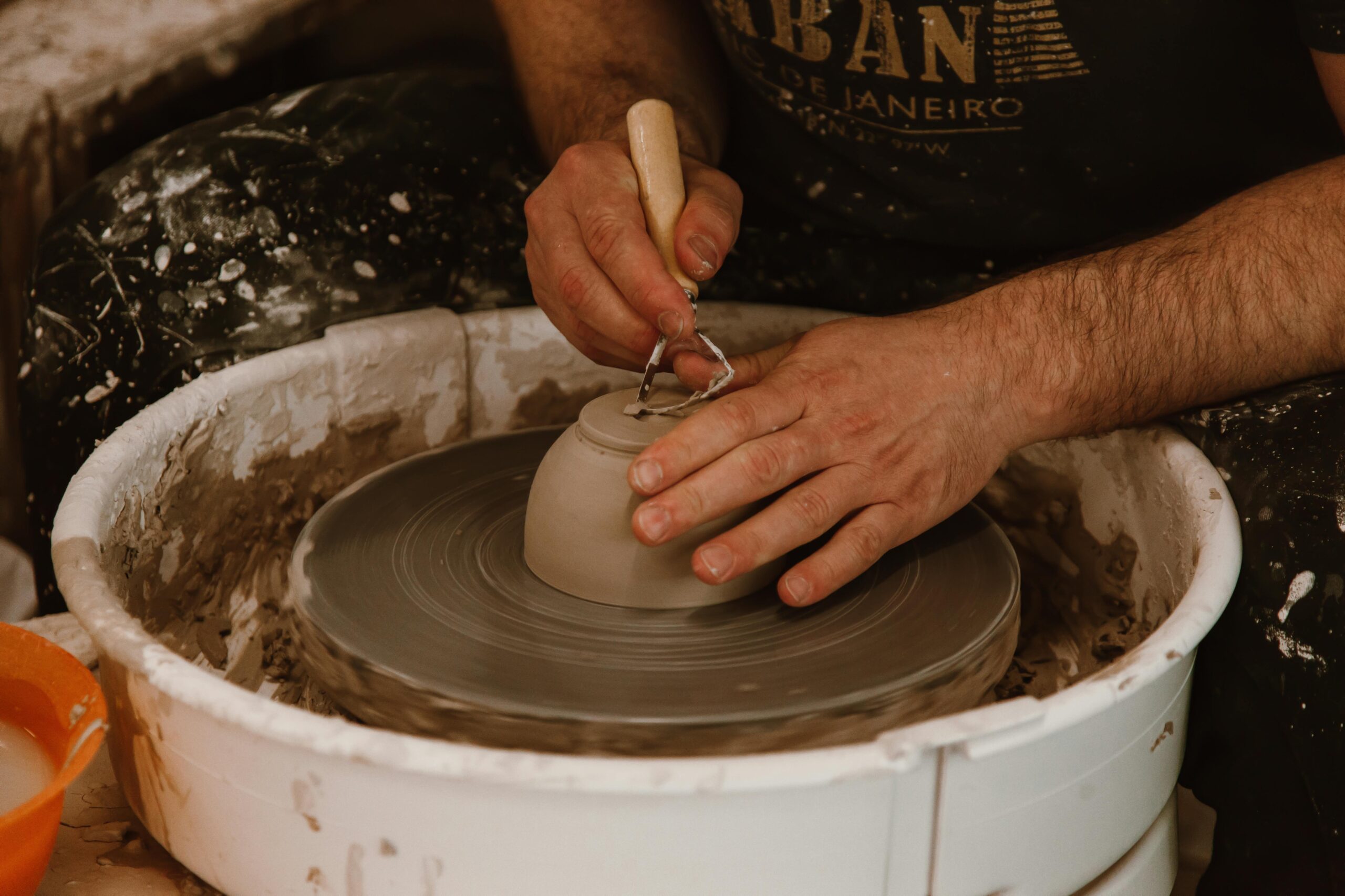 Close-up of hands crafting pottery on a wheel, showcasing skill and artistry.