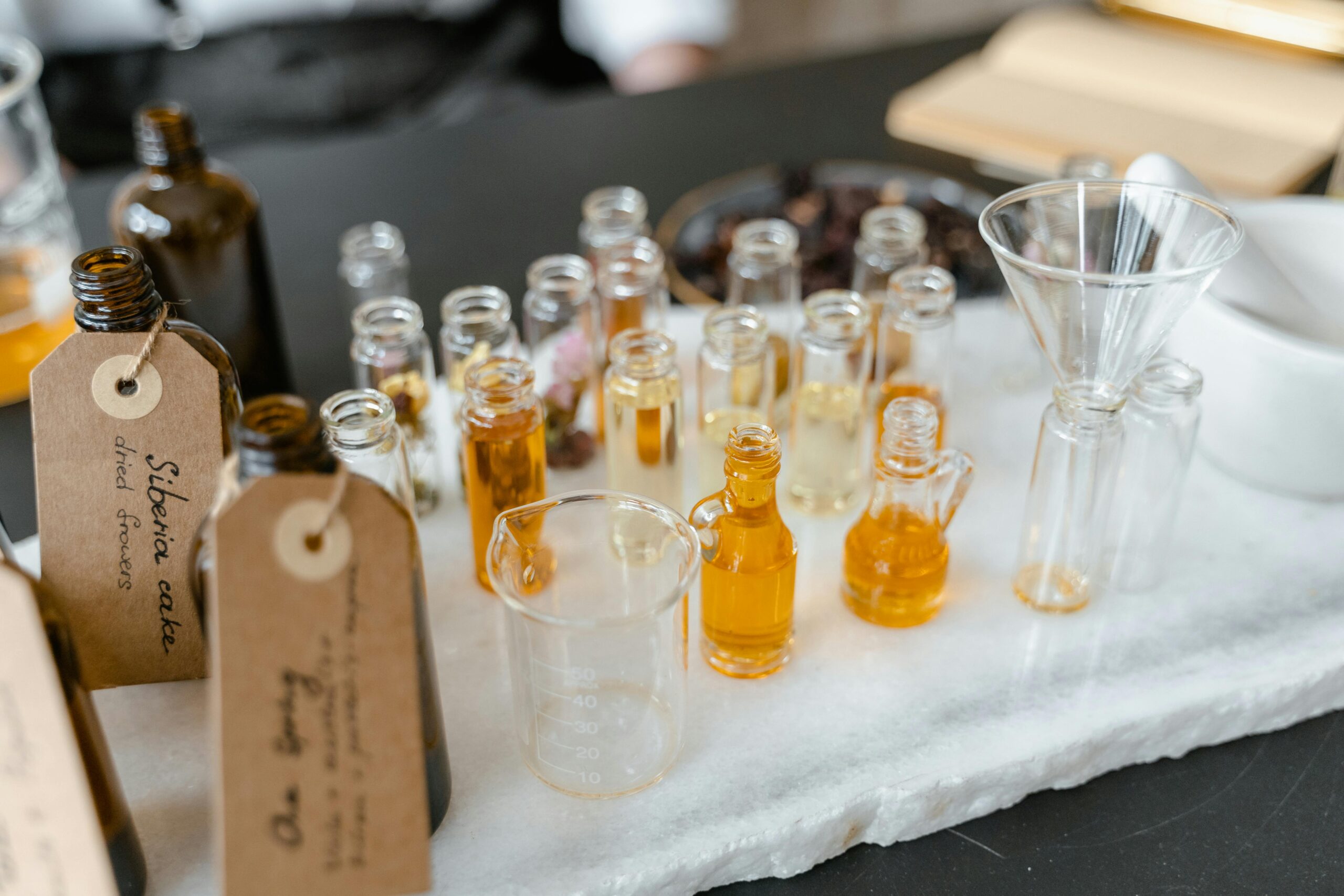 Aromatic essential oils in glass vials on a white surface, arranged for aromatherapy use.